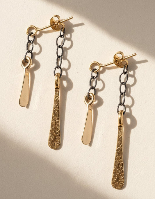 Two-tone chain dangler earrings with gold and dark hoop links and long teardrop charms