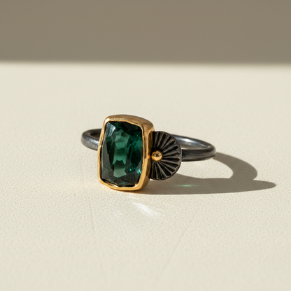 Tourmaline guppy ring showing deep-green rectangular stone, gold crown, fan setting