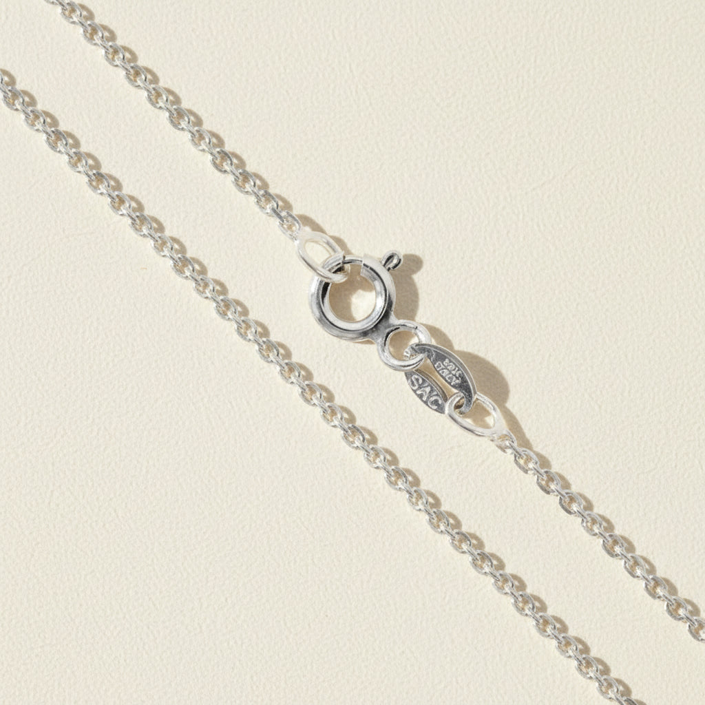 Silver cable chain necklace with circular clasp and oval logo charm