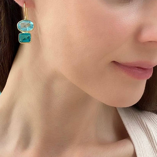 Gold hook earrings with aqua oval and mint green square stones, close-up