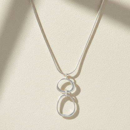 Organic circles necklace with two linked round charms on a thin chain