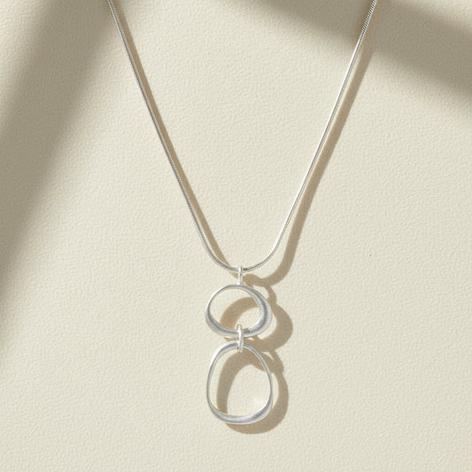 Organic circles necklace with two linked round charms on a thin chain