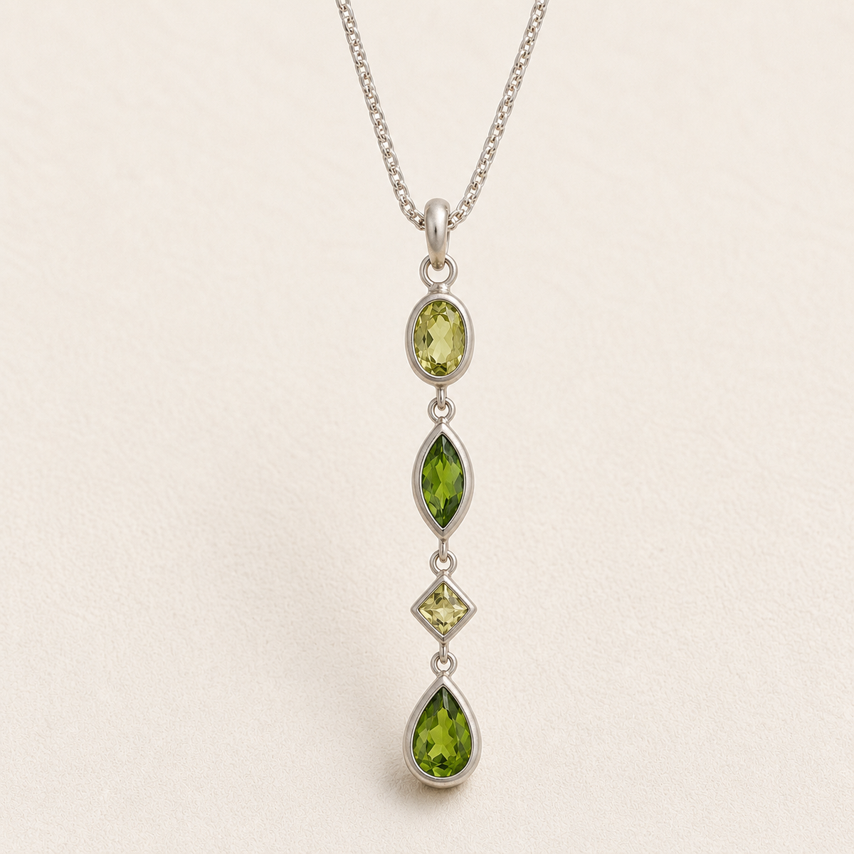 Gemstone drop necklace with four green faceted marquise pendants on silver chain