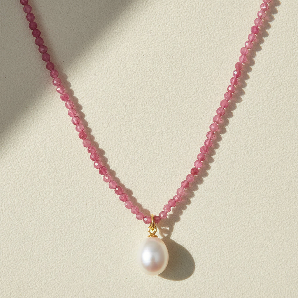 Pink beaded choker necklace with a round white pearl pendant on a gold bail