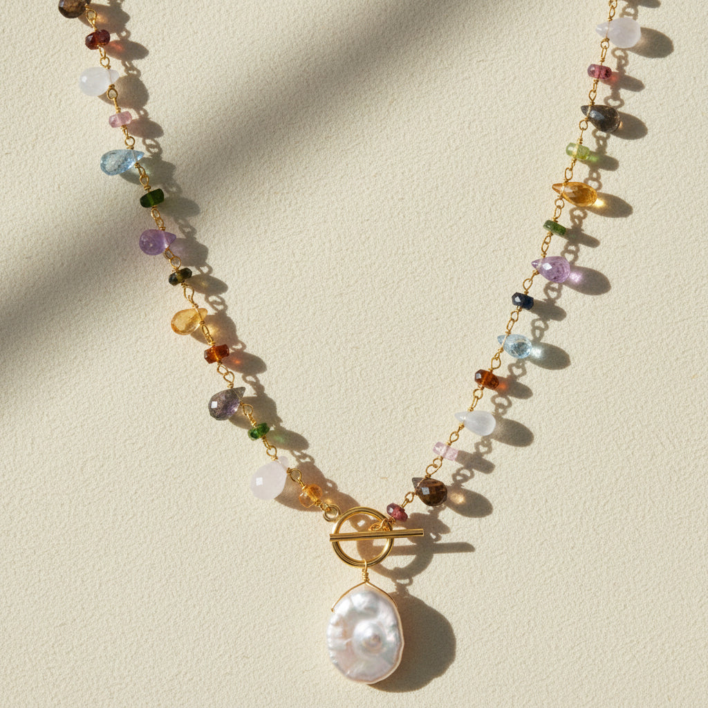 Gold toggle necklace with multicolor beads and a large white pearl drop pendant