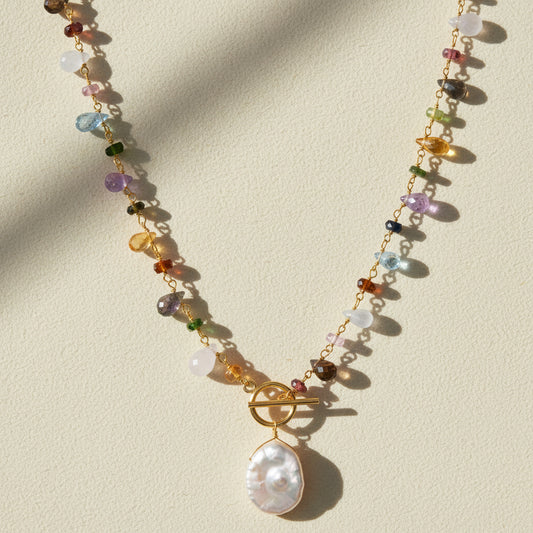 Gold toggle necklace with multicolor beads and a large white pearl drop pendant