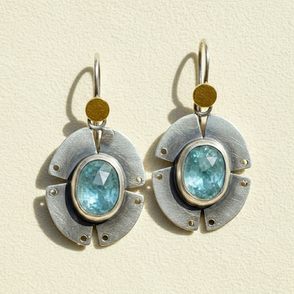 Pair of geometric drop earrings, gold caps with blue oval stones and circular metal frames