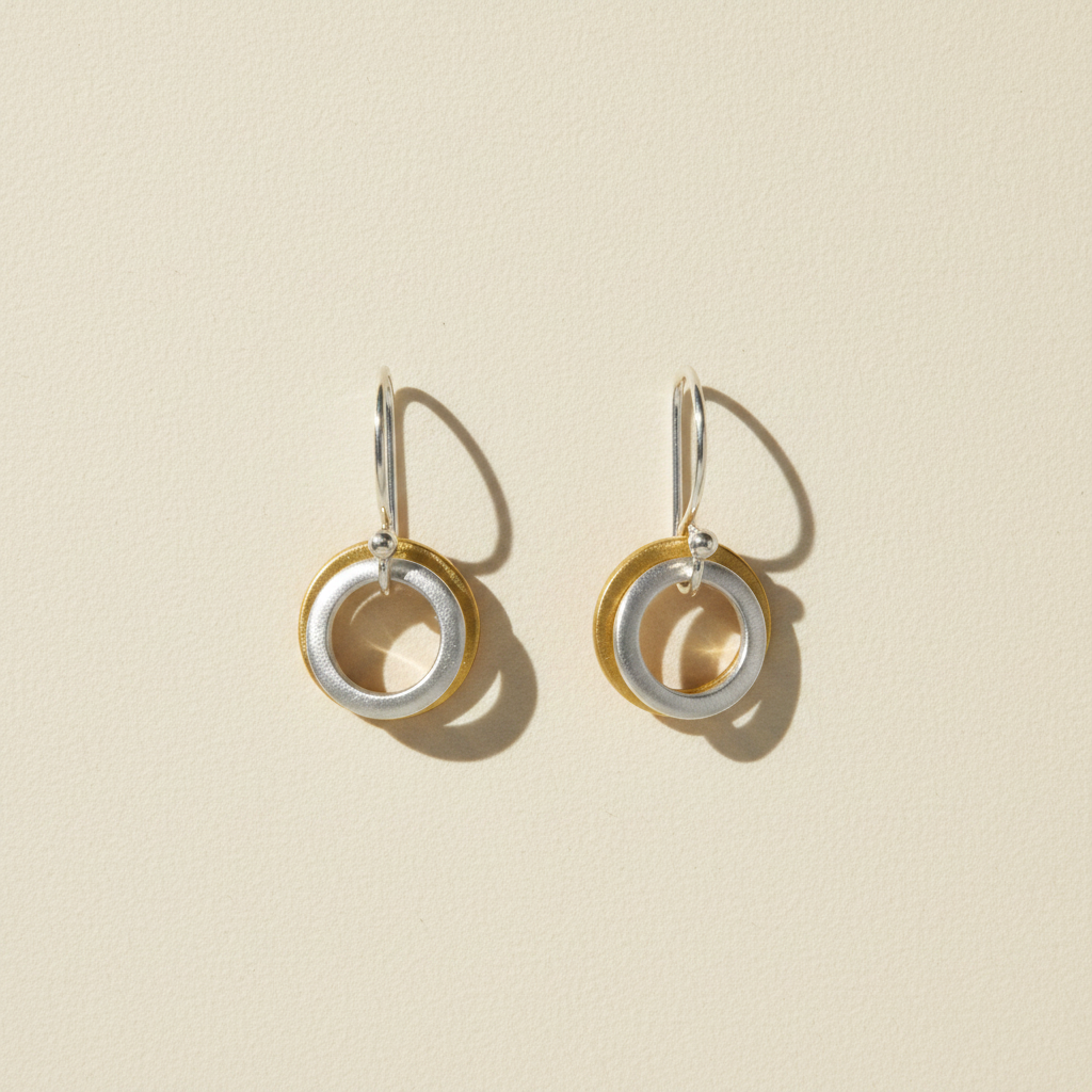 Two-tone small hoop earrings with stacked circle charms, gold and silver rings