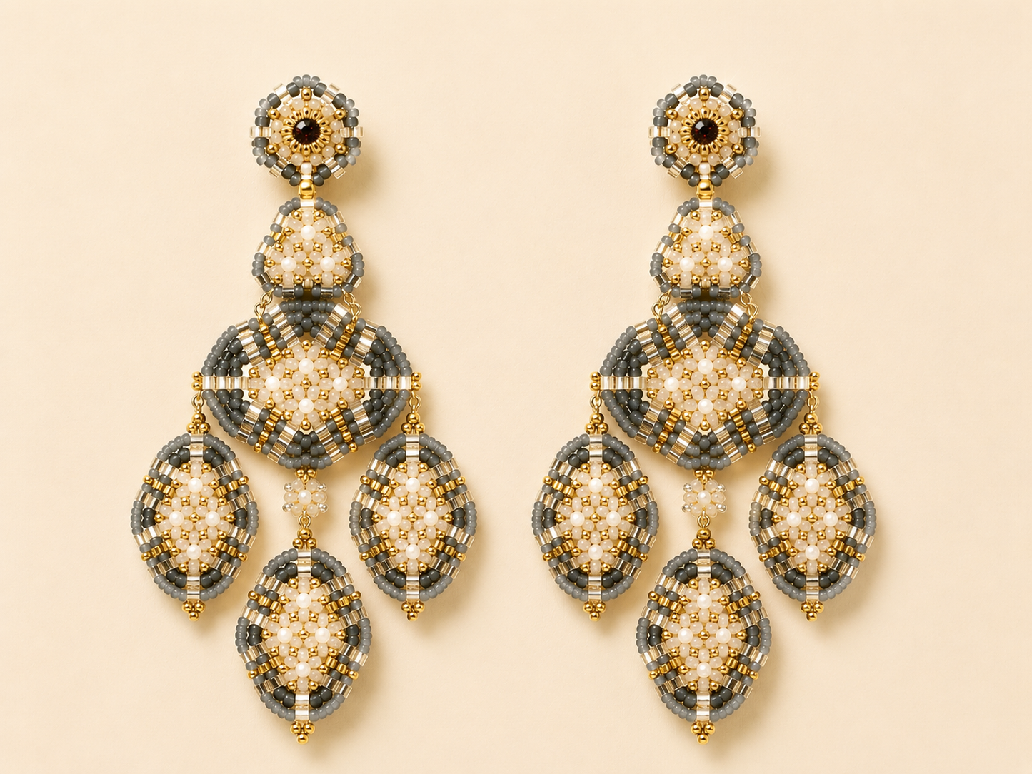 Beaded chandelier earrings with gold, cream, and black beadwork and teardrop drops