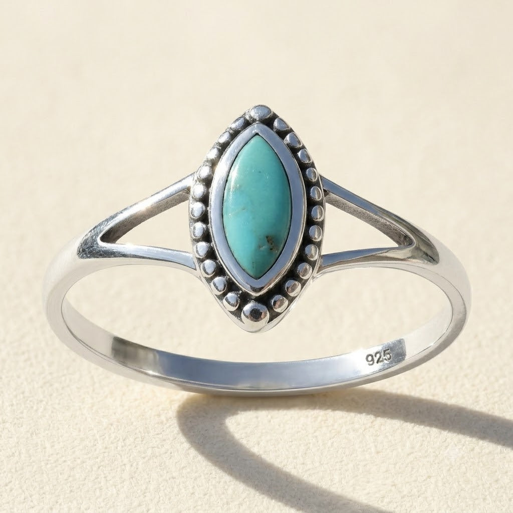 Silver oval turquoise gemstone ring with bezel and beaded border, marked 925