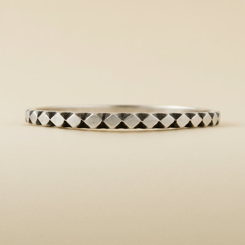 Silver-toned diamond pattern cuff bracelet with alternating black and metal facets