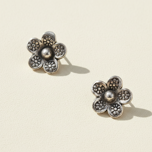 Sterling silver daisy stud earrings with textured petals and round center