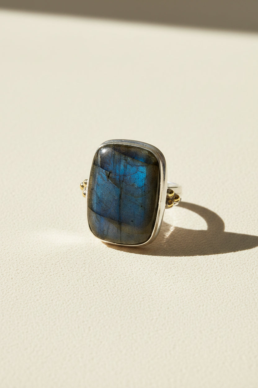 Oversized labradorite ring with blue square stone, silver bezel, and brass accents