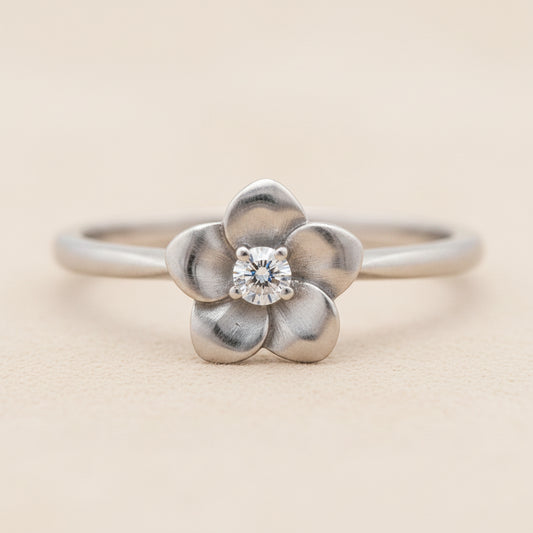 Flower ring with silver-tone band, four-petal flower and round crystal center