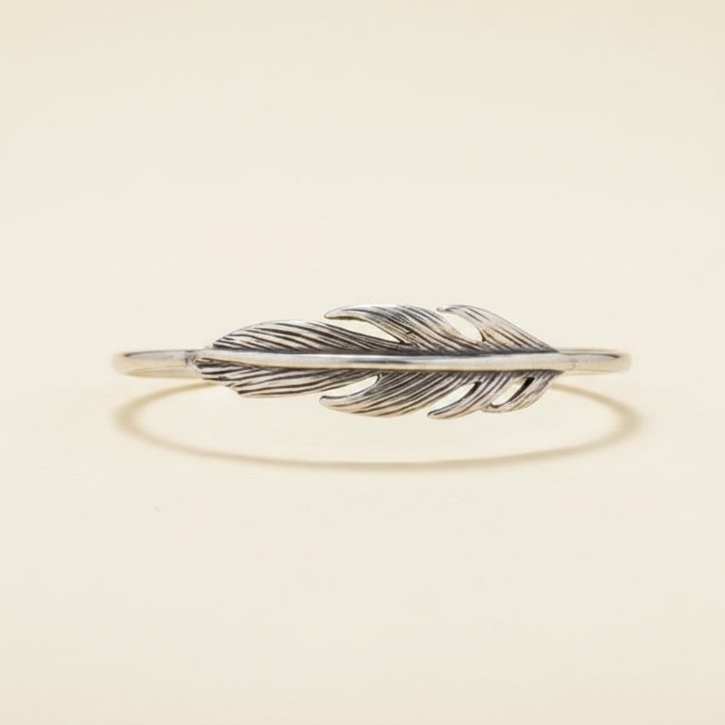 Silver feather-shaped bracelet on a white background