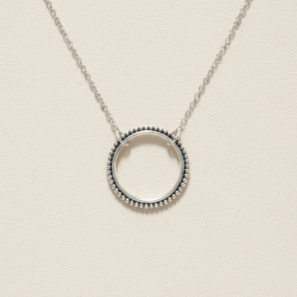 Silver circle pendant necklace with dotted round halo and link chain