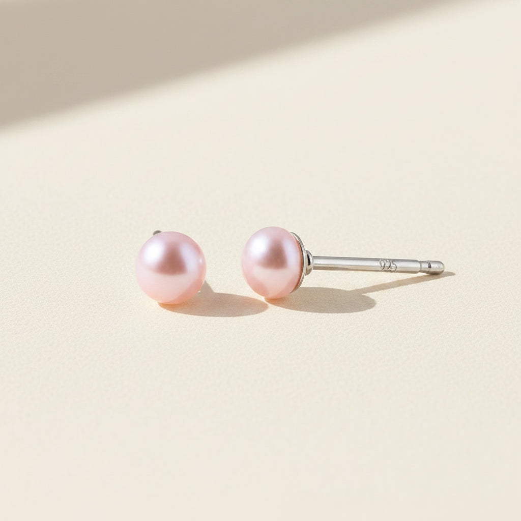 Pair of pink pearl earrings on a white background