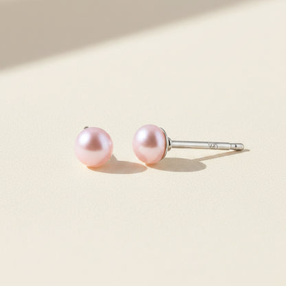 Pair of pink pearl earrings on a white background