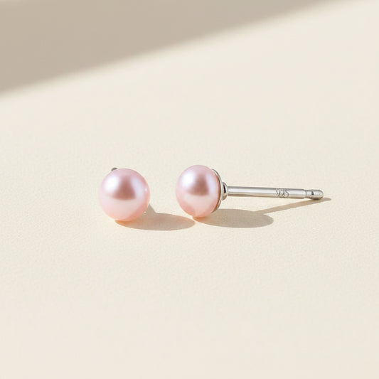 Pair of pink pearl earrings on a white background