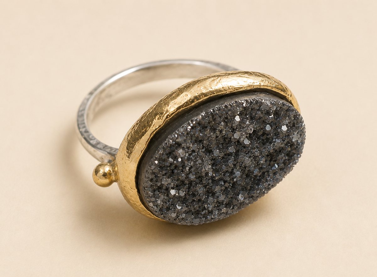 Two-tone oval gemstone ring with dark gray druzy oval and gold-tone frame