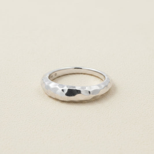 Hammered tapered band ring in silver-tone with faceted texture and rounded edges