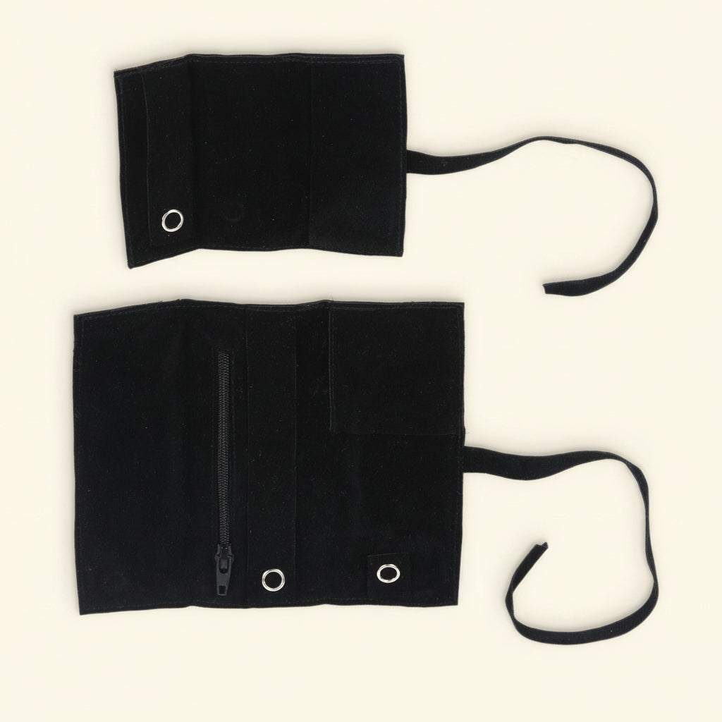 Black jewelry roll organizer with three folded panels and ribbon ties, metal eyelets.