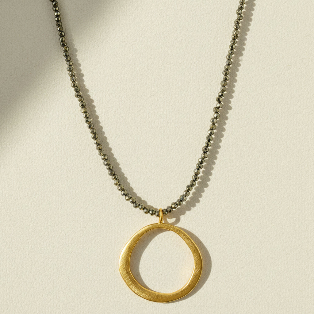 Gold open-circle pendant necklace with short chain and circular charm at center