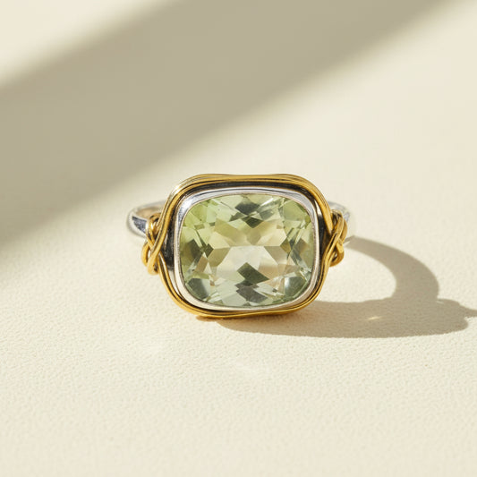Two-tone ring with rectangular pale green gemstone in gold bezel and silver accents