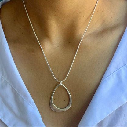 Open teardrop pendant necklace hanging on silver chain