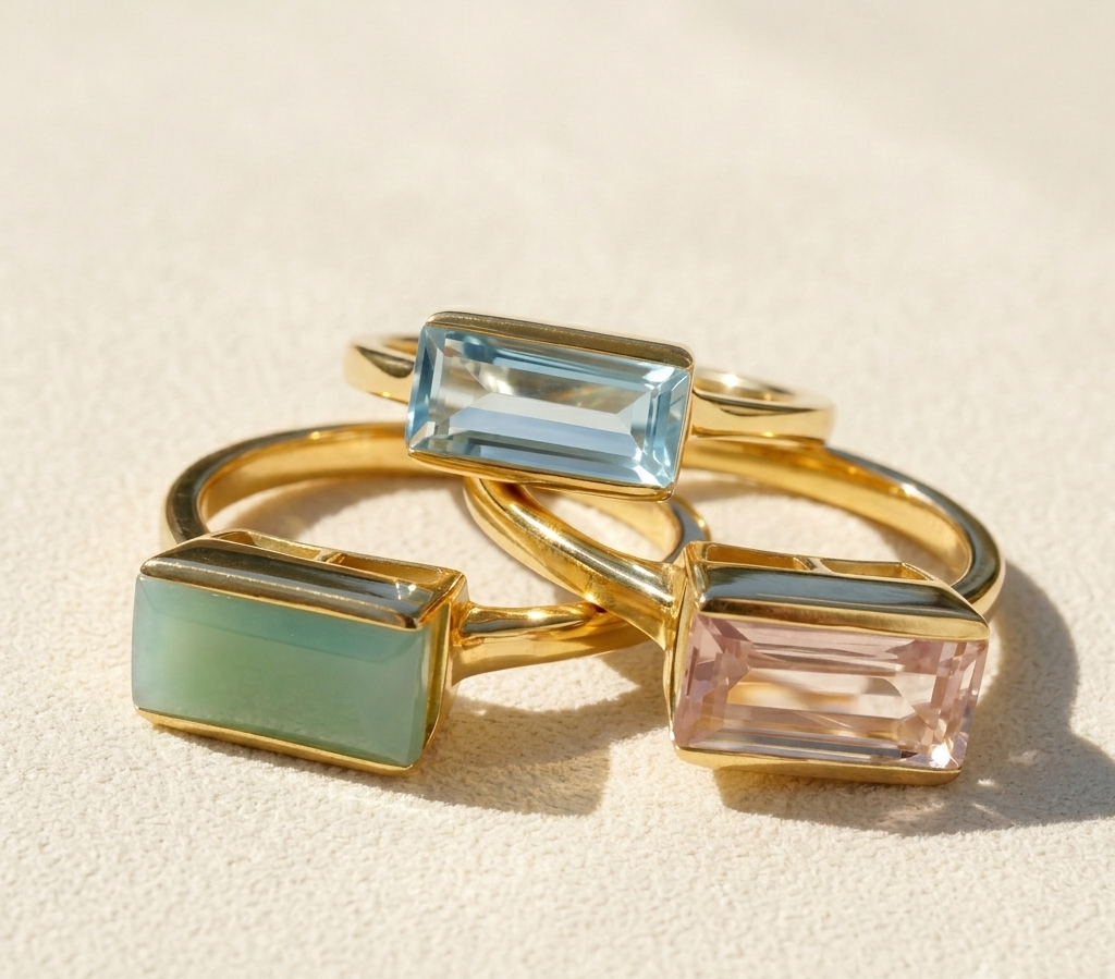 Gold-tone ring with emerald-cut gemstone, square prong setting