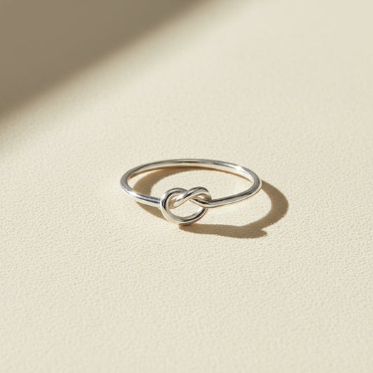 Silver love knot ring with small twisted knot detail on slim band
