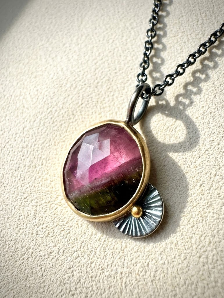 Guppy necklace pendant with oval pink gemstone, gold bezel, fan-like charm, metal chain