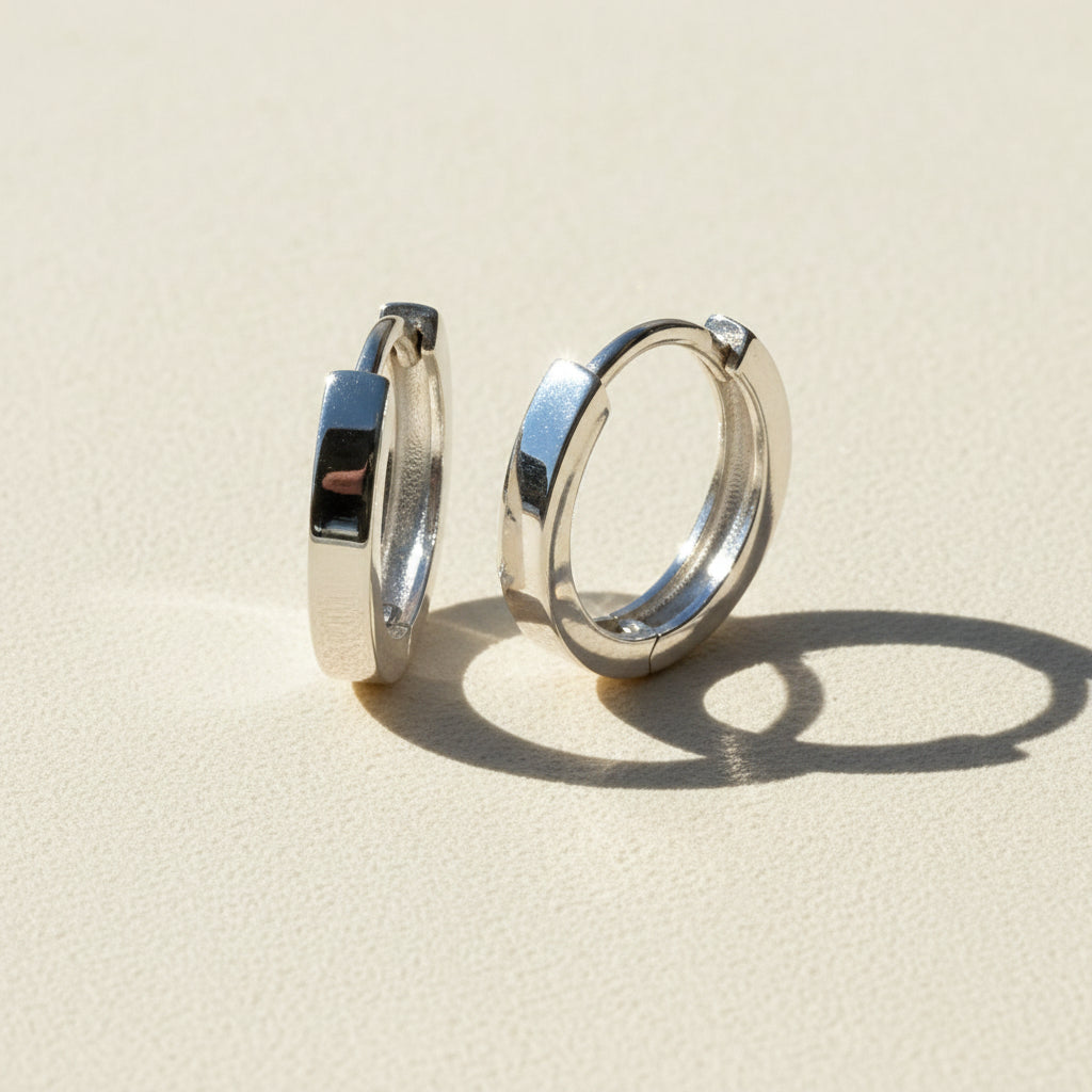 Narrow huggie hoop earrings, silver-tone metal with glossy inner hinge