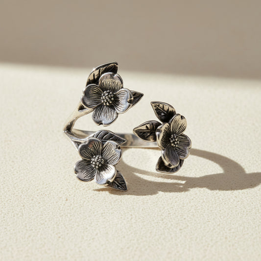 Silver flower ring with three dogwood blossoms and leaves, openwork band