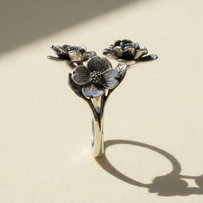 Silver dogwood flower ring with three blossoms on curved band, side view