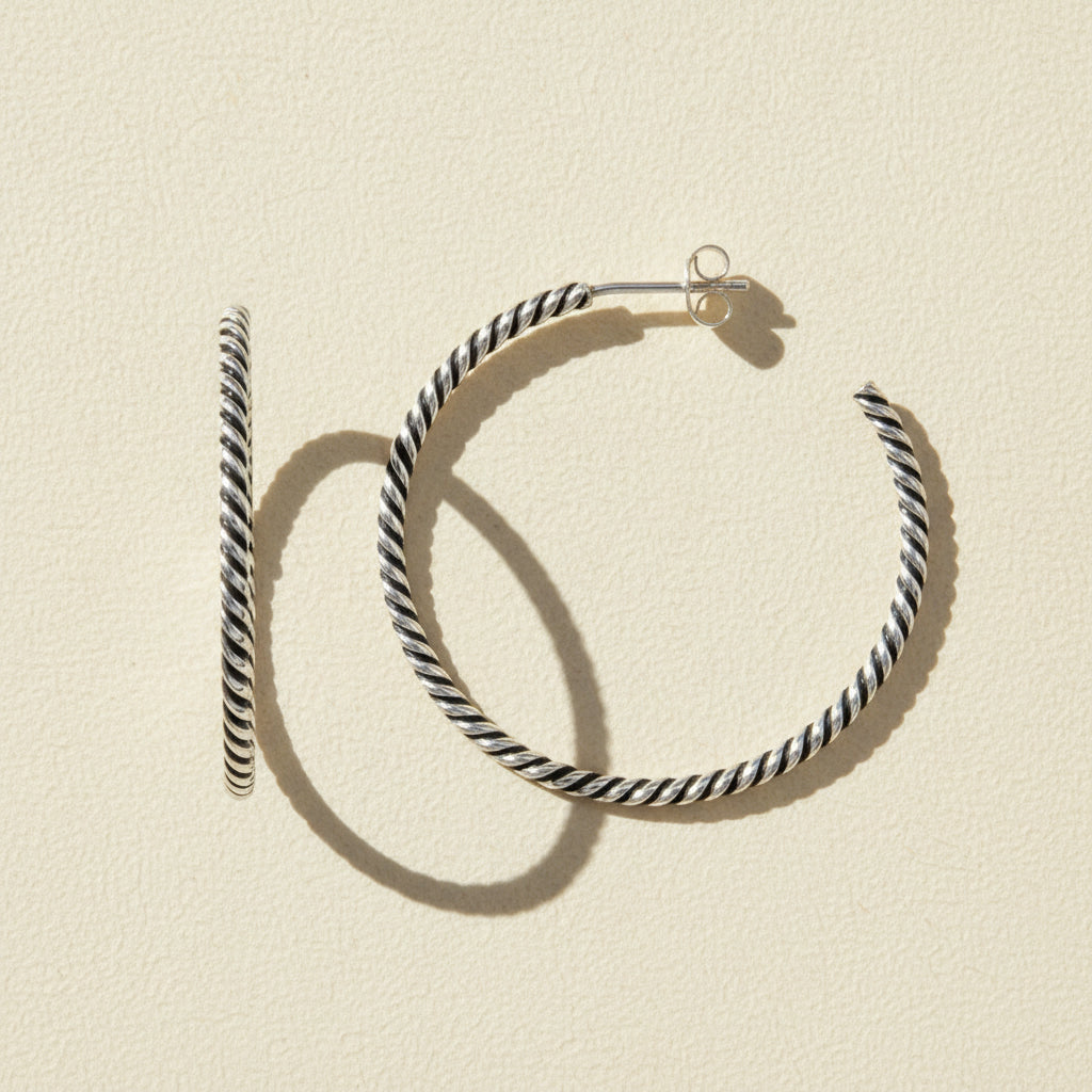 Black and white striped hoop earrings on a white background