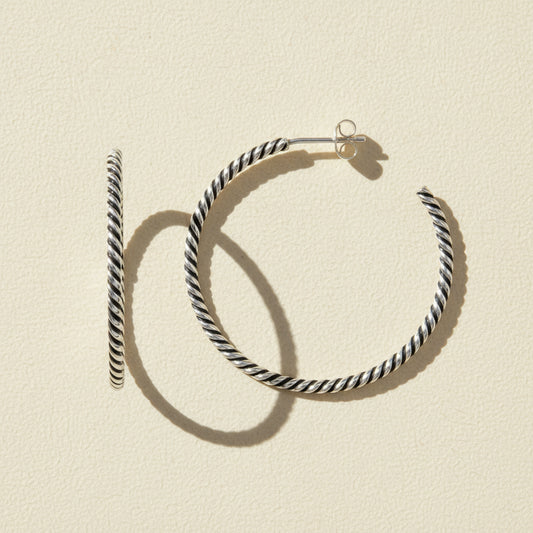 Black and white striped hoop earrings on a white background