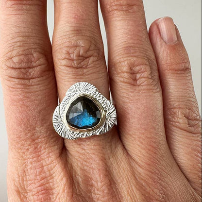 Sterling silver ring with teardrop labradorite center and textured bezel setting