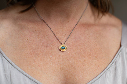 Oval necklace with mixed metal chain and blue oval glass pendant
