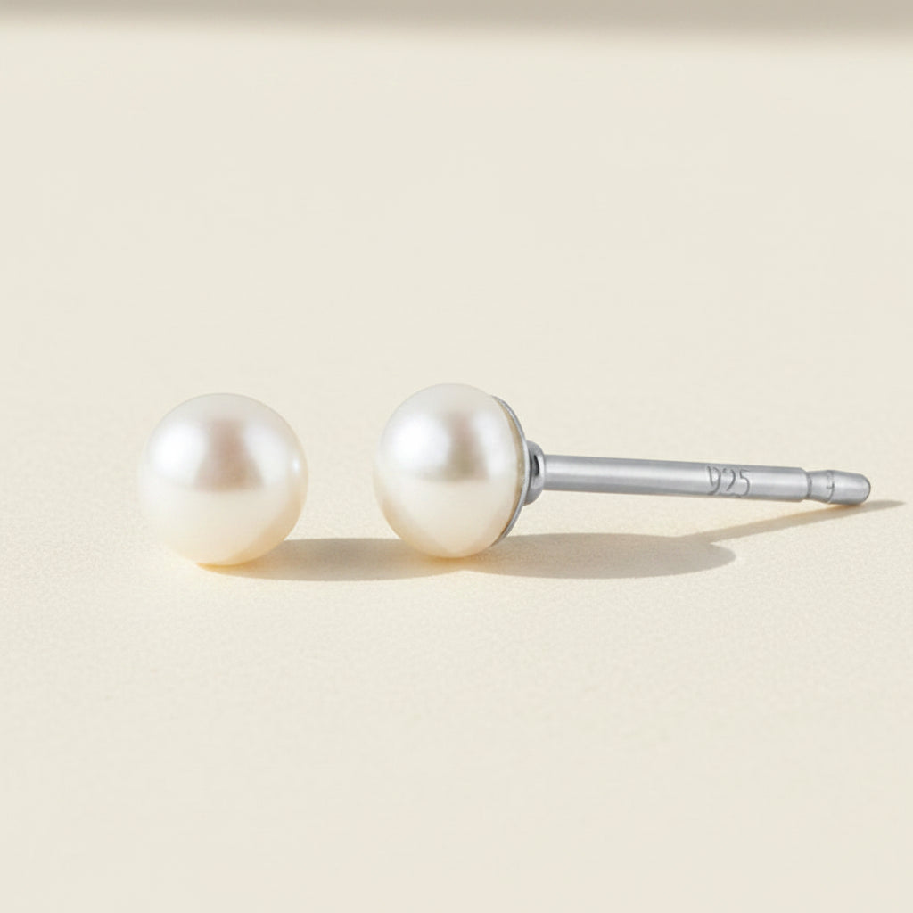 Pair of pearl stud earrings on a white background