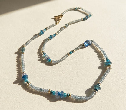 Blue beaded choker necklace with gold bird charm and tiny teal bead accents