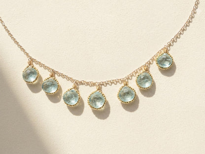 Gold-tone beaded briolette necklace with teardrop aqua stones and linked chain