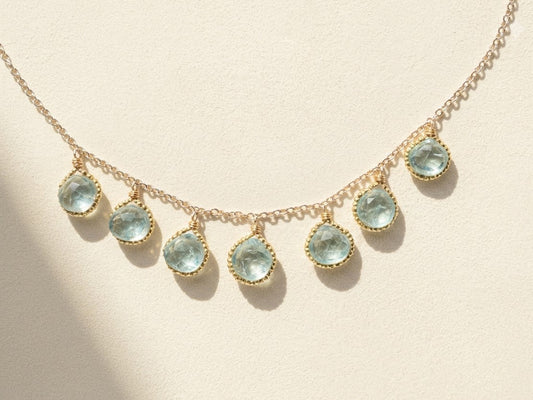 Gold-tone beaded briolette necklace with teardrop aqua stones and linked chain