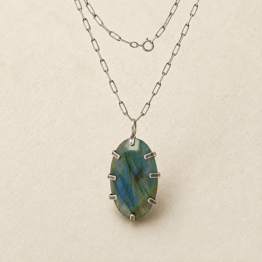 Oval labradorite pendant on silver-tone chain, faceted blue-green stone with metal prongs