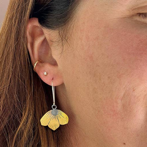 Gold-tone flower dangle earrings with hook backs and round light center