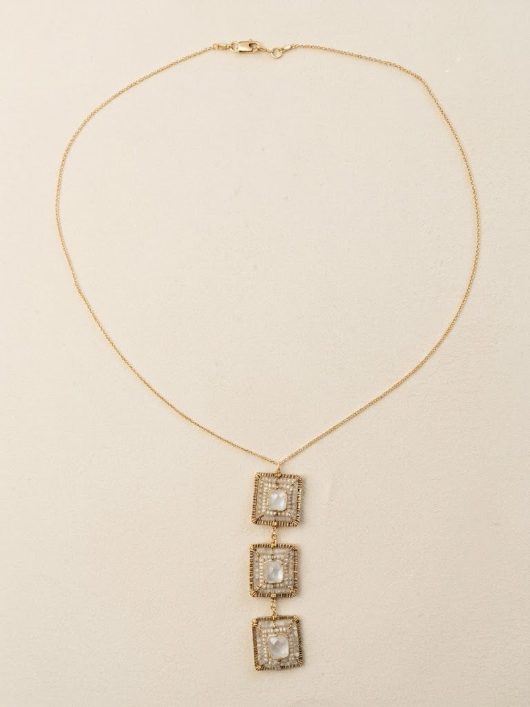 Gold-tone drop necklace with three square charms and pearl-like center stones