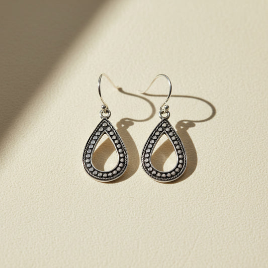 Silver-tone teardrop earrings with dark beaded trim and hook backs