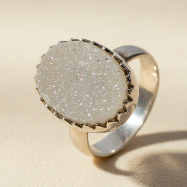 Large oval druzy ring with white-silver glitter stone in a gold-tone bezel