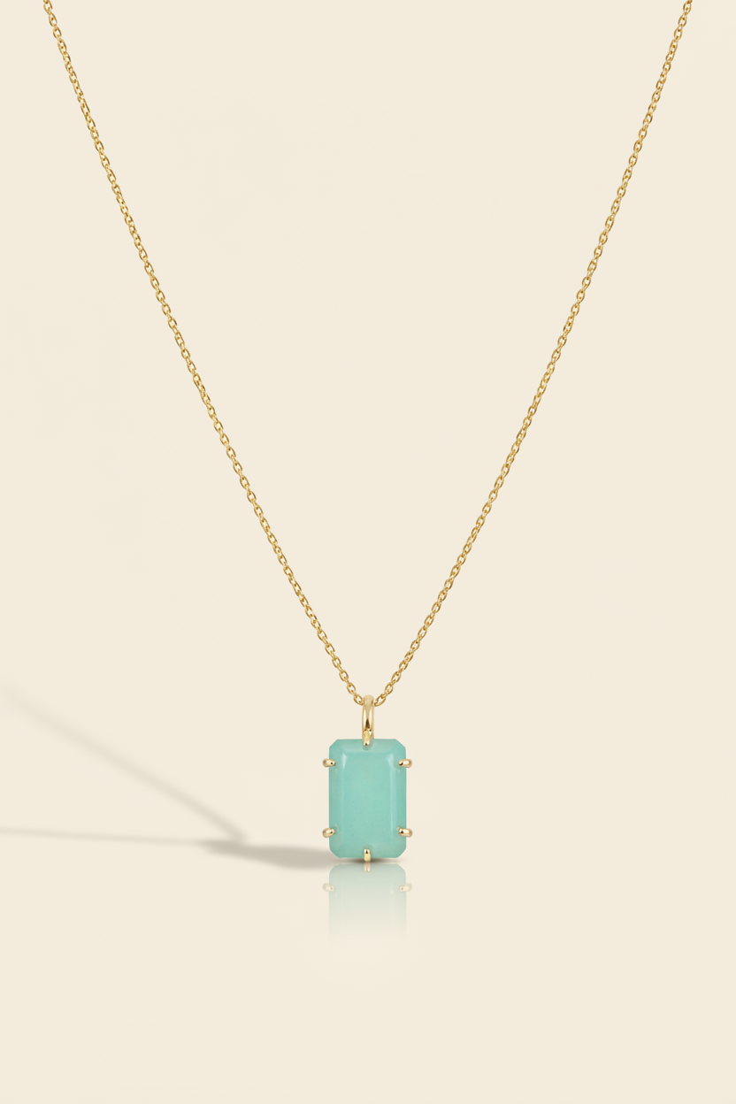 Aqua blue emerald-cut pendant necklace with gold-tone chain and bezel-set stone