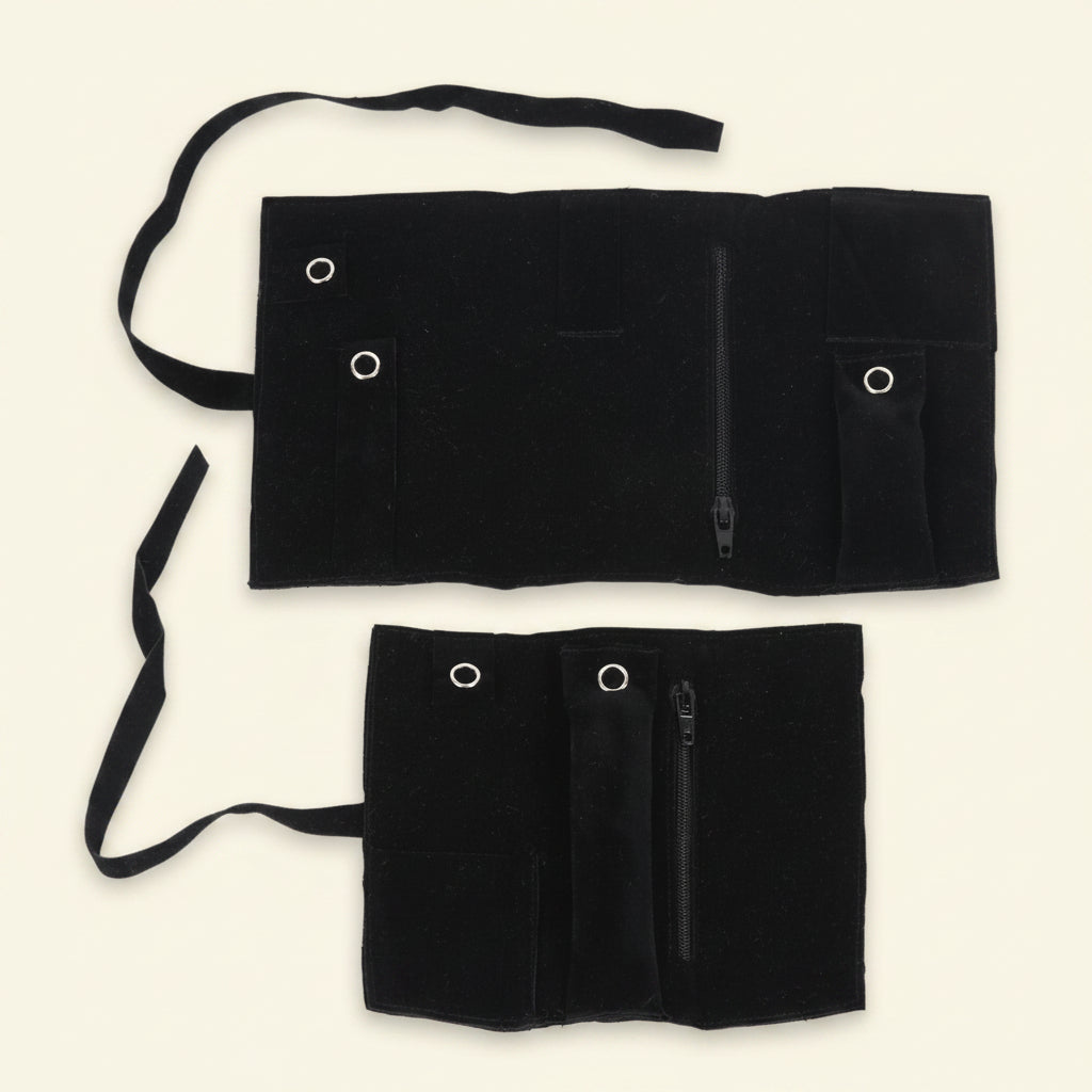 Black jewelry roll with snap buttons and stitched compartments plus zipper
